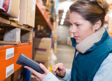 a woman holding a scanner up to a box in a warehouse in Rhode Island